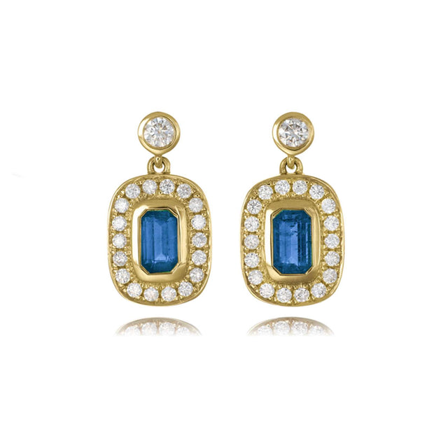Gold earrings with blue gemstones and clear stones on a white background