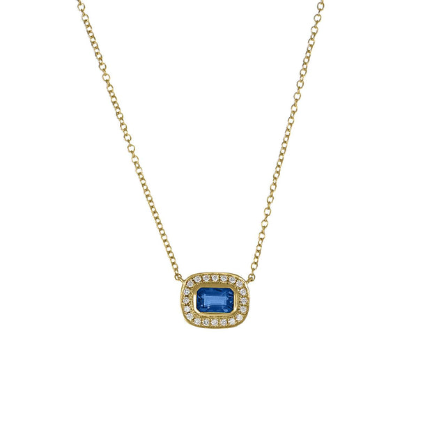 Gold necklace with a blue gemstone pendant on a white background