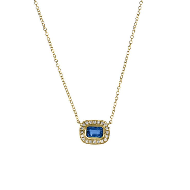 Gold necklace with a blue gemstone pendant on a white background